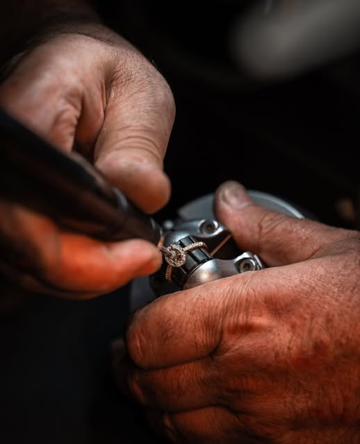 Goldschmied fasst einen Diamanten in der Werkstatt