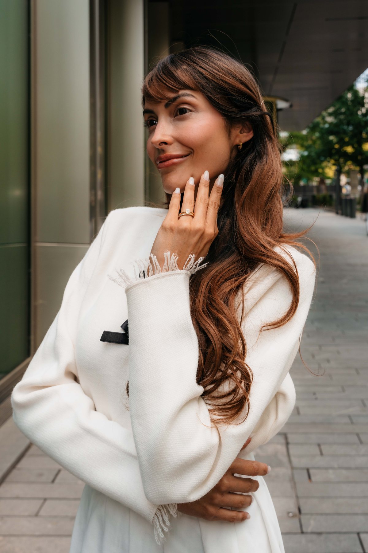 Frau mit Verlobungsring und Ehering an der Hand